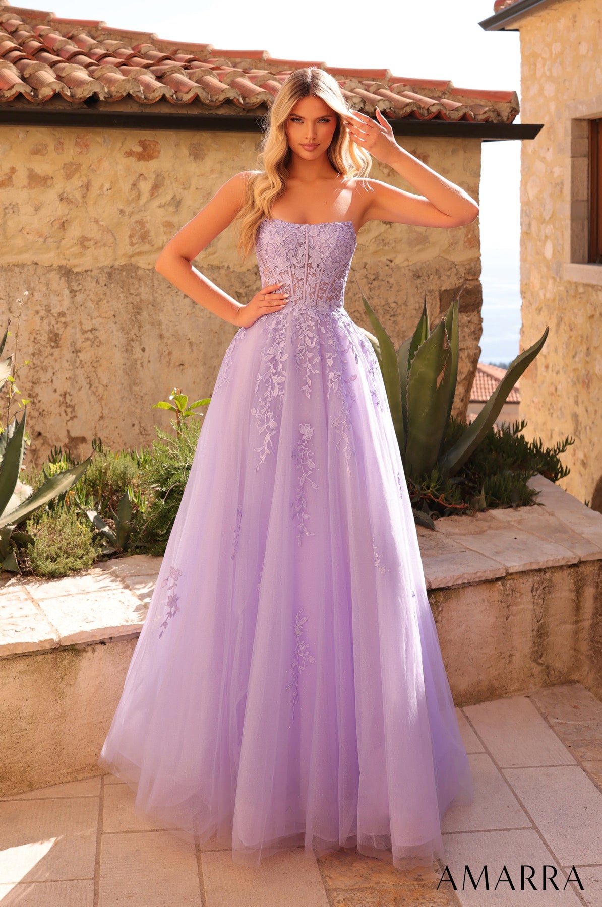 Woman in a lavender evening gown standing outdoors with a building in the background THE BRIDAL COMPANY